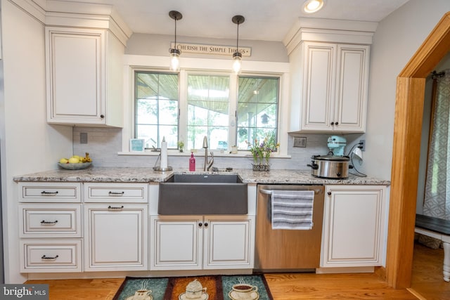 kitchen with light hardwood / wood-style flooring, backsplash, stainless steel dishwasher, light stone countertops, and sink