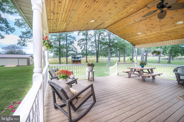 wooden deck with ceiling fan and a lawn