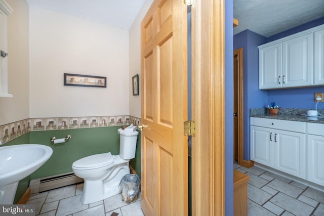 bathroom featuring a baseboard radiator, toilet, tile patterned floors, and a textured ceiling