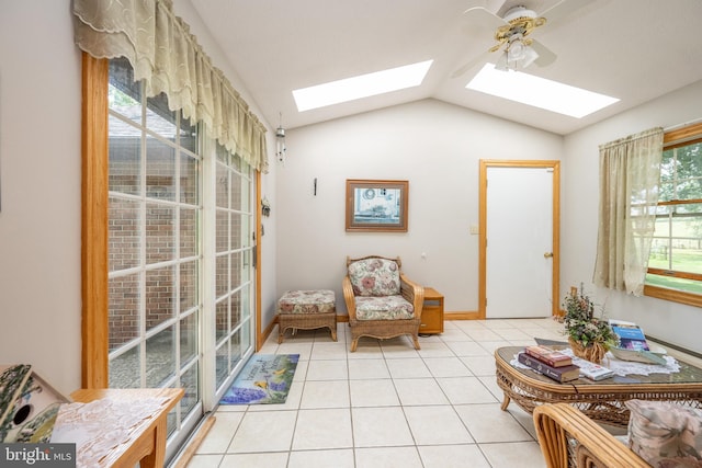 sitting room with plenty of natural light, lofted ceiling with skylight, ceiling fan, and light tile patterned floors