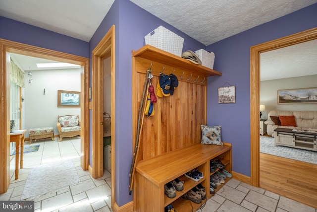 mudroom with a textured ceiling and light tile patterned floors