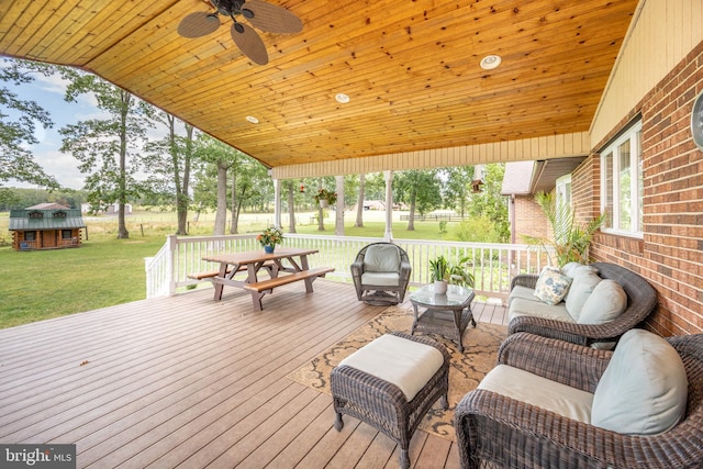 wooden terrace with a lawn, outdoor lounge area, and ceiling fan