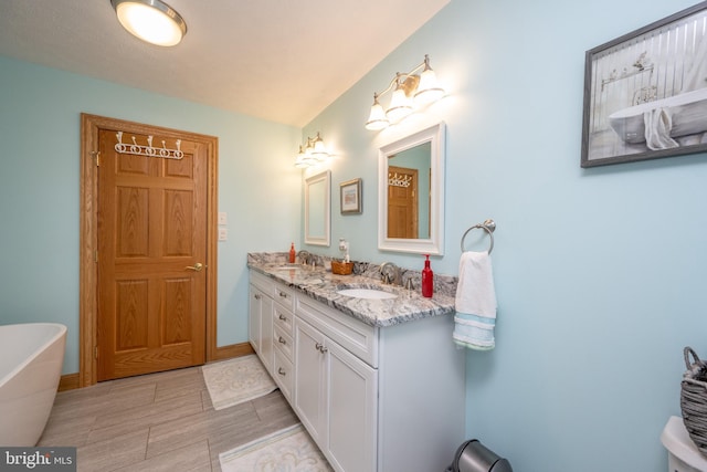 bathroom featuring dual vanity, tile patterned floors, and a bathtub