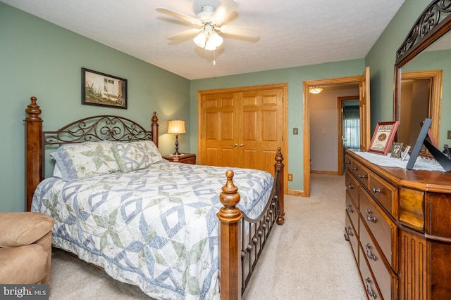 bedroom with ceiling fan, light carpet, a closet, and a textured ceiling