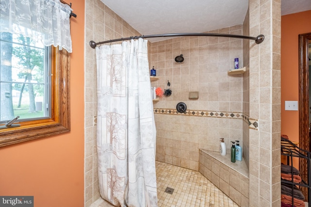 bathroom with curtained shower and a textured ceiling