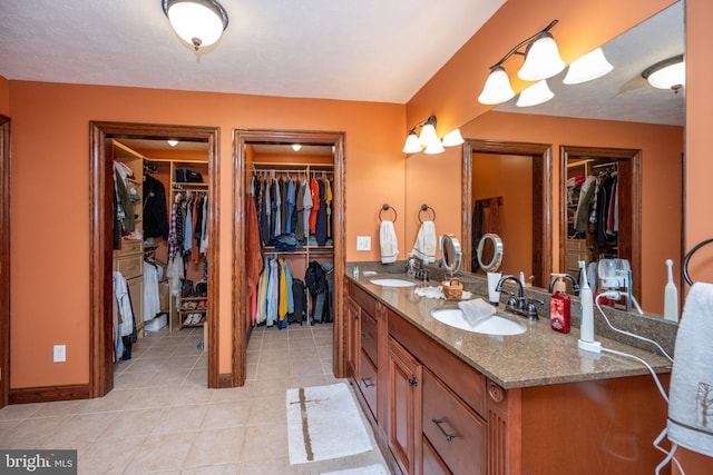 bathroom with dual bowl vanity and tile patterned floors