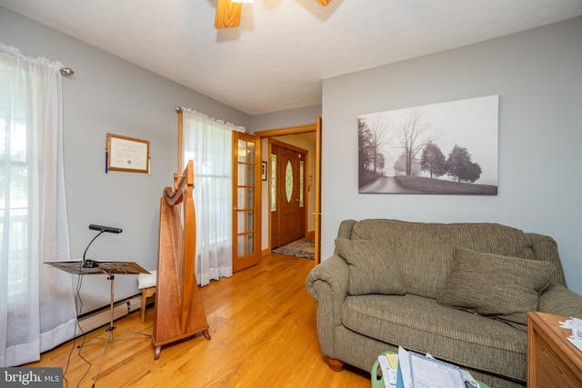 living room with light hardwood / wood-style floors and ceiling fan