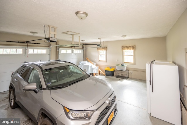 garage with a garage door opener and white refrigerator