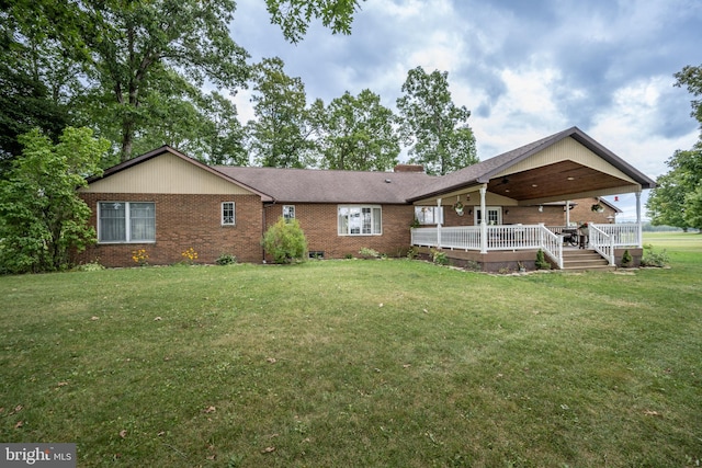 back of house featuring a deck and a lawn