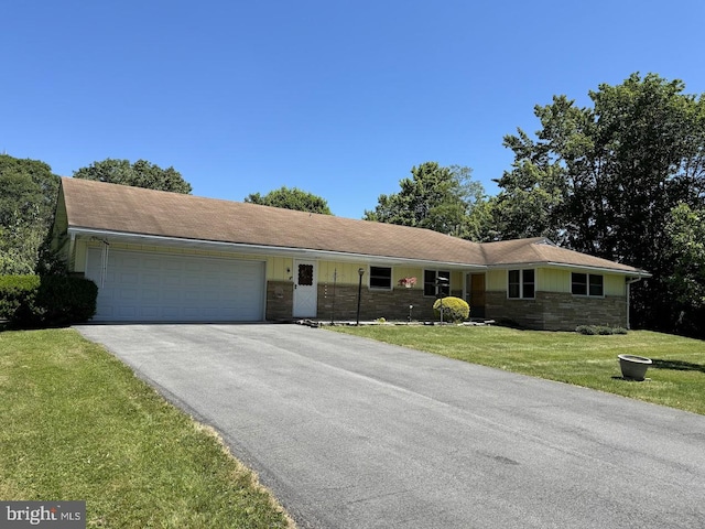 ranch-style house featuring a garage and a front yard