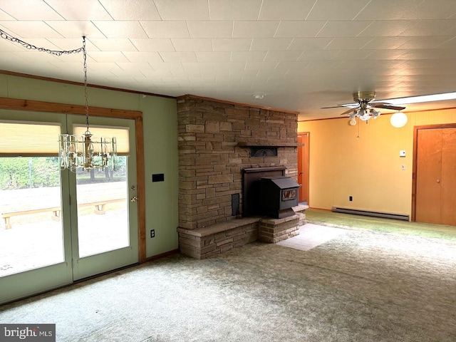 unfurnished living room featuring a wood stove, carpet, ceiling fan with notable chandelier, a baseboard radiator, and ornamental molding