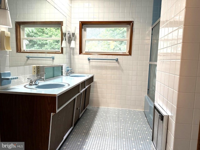 bathroom featuring dual vanity, plenty of natural light, tile walls, and tile patterned floors