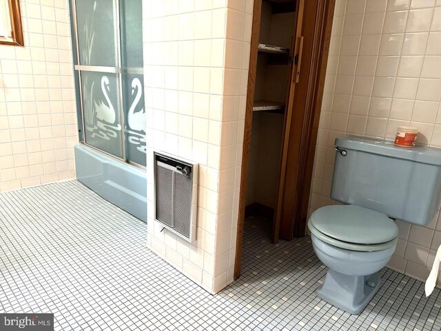 bathroom with tile walls, tile patterned floors, and toilet