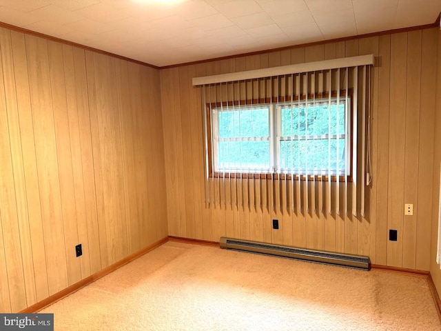 empty room featuring wood walls, light colored carpet, and a baseboard radiator