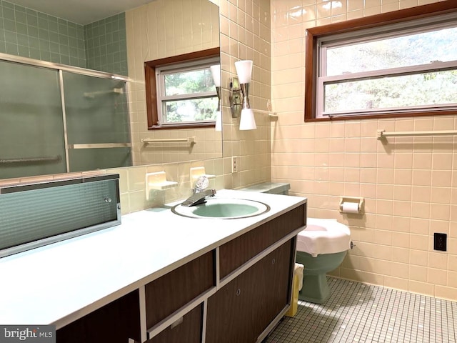 bathroom featuring tile patterned flooring, tile walls, toilet, and vanity