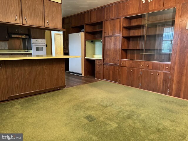 kitchen with extractor fan, dark carpet, and white appliances