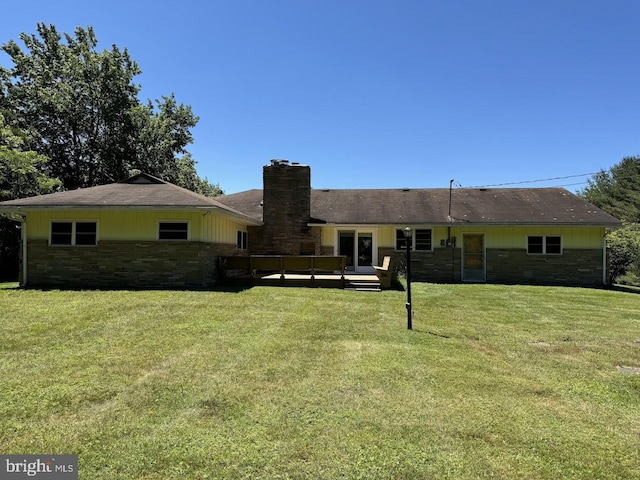 rear view of property featuring a yard and a wooden deck