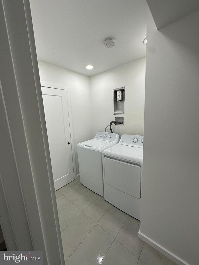 clothes washing area featuring light tile patterned flooring and independent washer and dryer