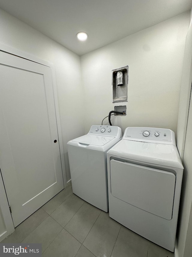 laundry room with washer and clothes dryer and light tile patterned flooring