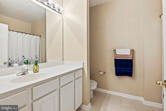 bathroom with toilet, vanity, and tile patterned flooring