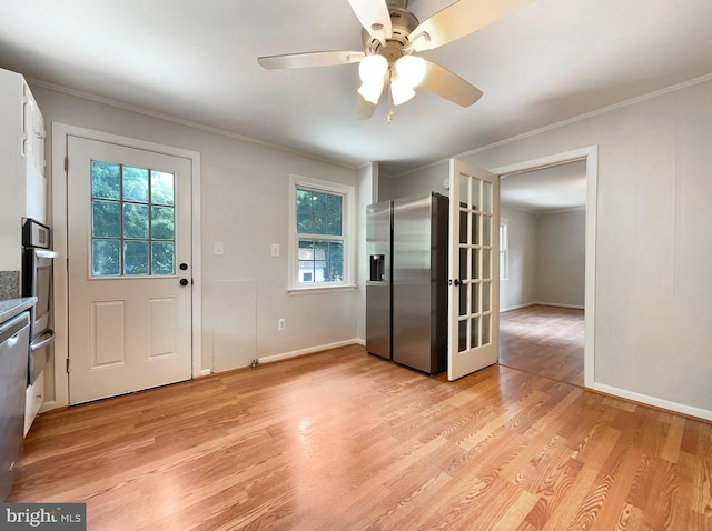 interior space with crown molding, ceiling fan, and light hardwood / wood-style flooring