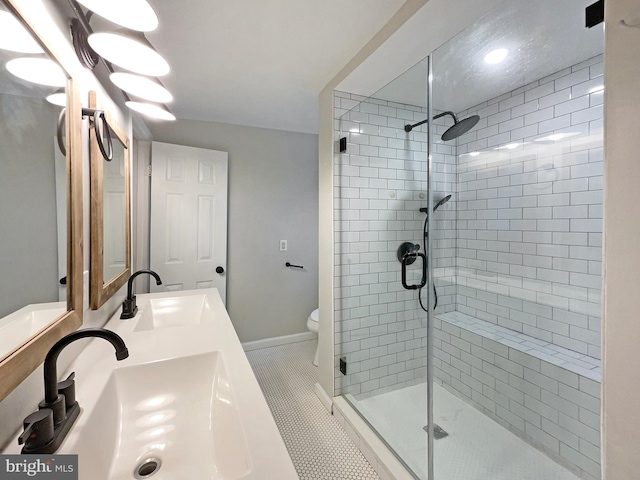 bathroom featuring sink, a tile shower, and toilet