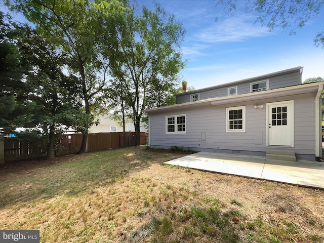 back of house featuring a patio area and a lawn