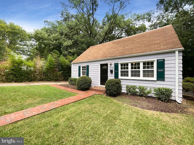 cape cod house with a front yard