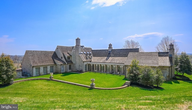 rear view of property with a lawn