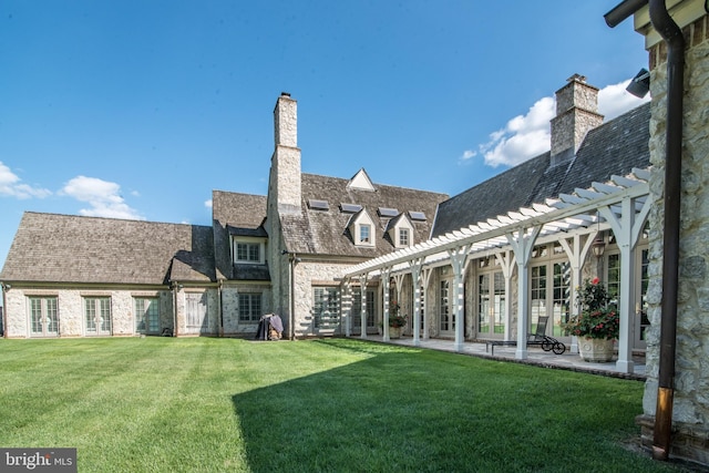 rear view of house featuring a yard, a patio area, and a pergola