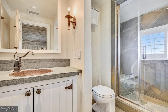 bathroom featuring vanity, an enclosed shower, and toilet