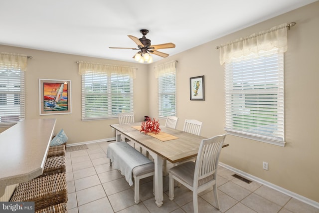 tiled dining space with ceiling fan