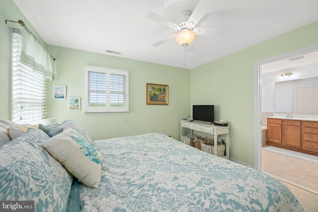 bedroom with ceiling fan, connected bathroom, sink, and light tile patterned floors