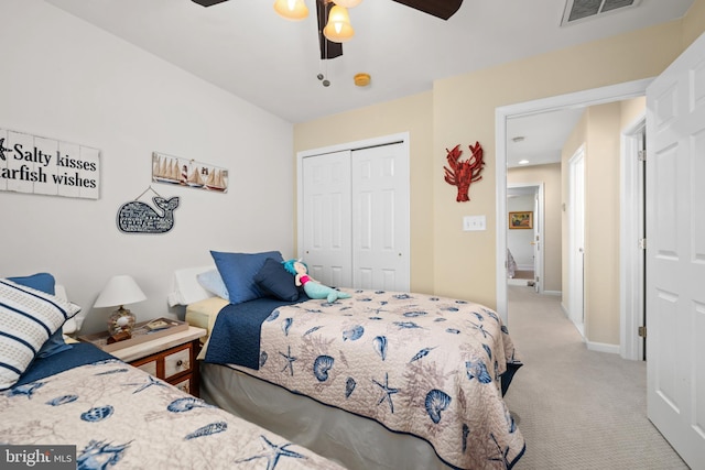 bedroom featuring ceiling fan, light carpet, and a closet