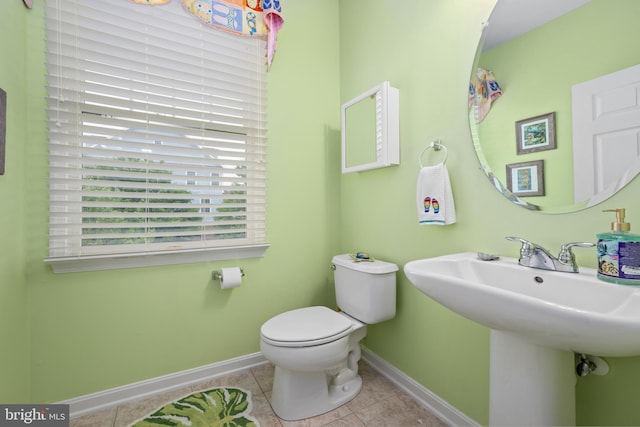 bathroom with sink, toilet, and tile patterned flooring