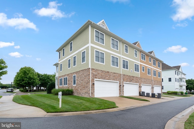 view of side of property with central AC, a garage, and a yard