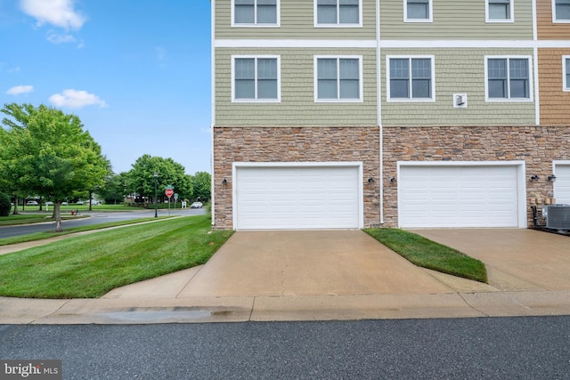 exterior space featuring central AC, a garage, and a front yard