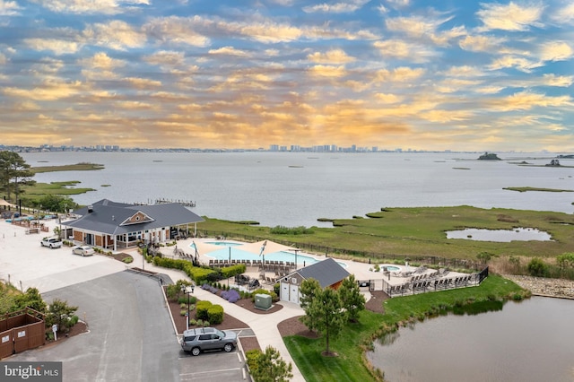 aerial view at dusk featuring a water view