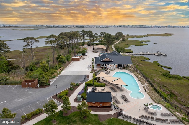 aerial view at dusk featuring a water view