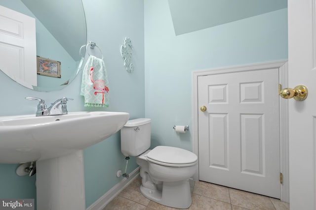 bathroom with tile patterned flooring, vaulted ceiling, and toilet