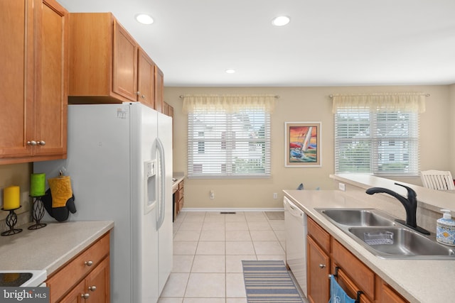 kitchen featuring white appliances, sink, and light tile patterned floors