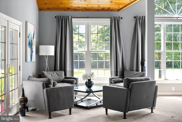 living area featuring light colored carpet, lofted ceiling, and wooden ceiling