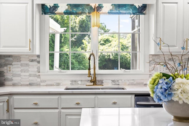 kitchen featuring white cabinetry, sink, tasteful backsplash, and a healthy amount of sunlight