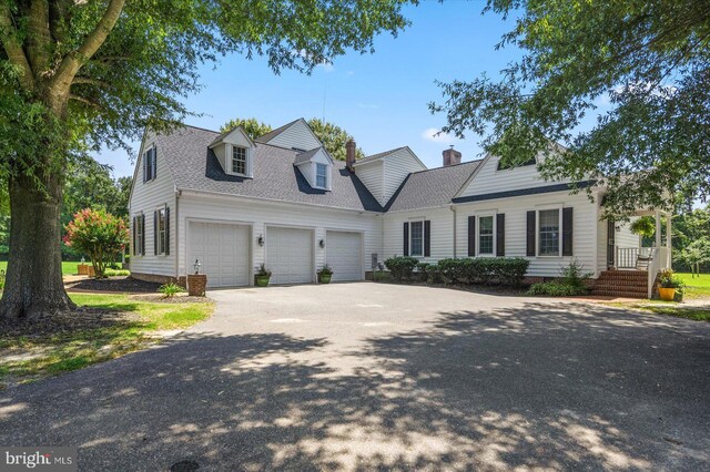 new england style home featuring a garage