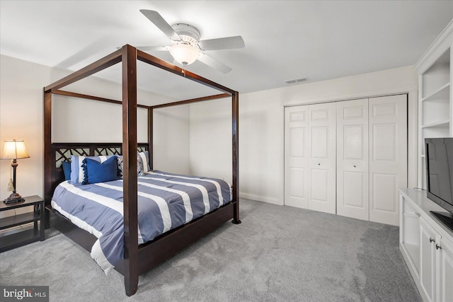 carpeted bedroom featuring ceiling fan and a closet