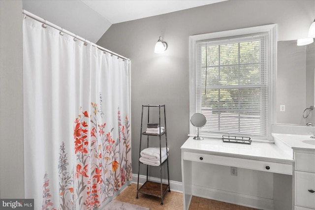 bathroom with vanity and vaulted ceiling