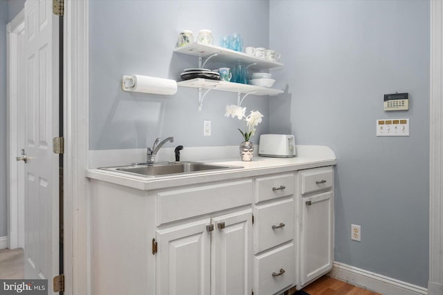 interior space with sink and white cabinets