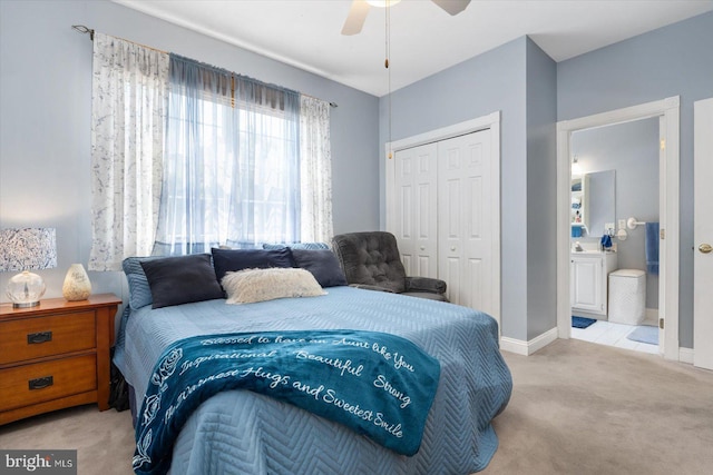 bedroom featuring light colored carpet, ceiling fan, and a closet