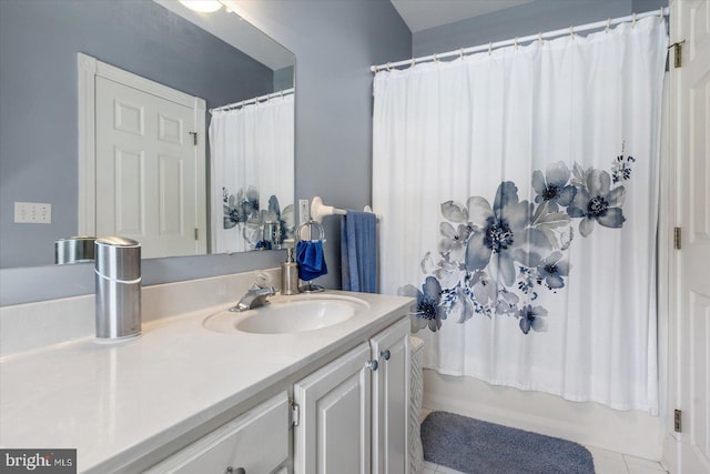 bathroom with shower / tub combo with curtain, vanity, and tile patterned flooring