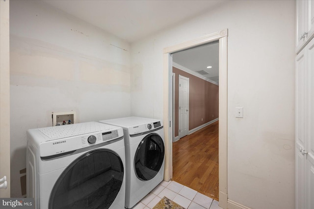 washroom with light tile patterned floors, crown molding, and washer and dryer